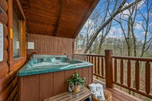 a hot tub on the deck of a cabin at Log Cabin, Hot Tub, Fireplace, Pool Table & Views! in Sevierville