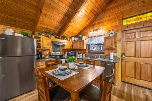 a kitchen with a table and a refrigerator at Log Cabin, Hot Tub, Fireplace, Pool Table & Views! in Sevierville