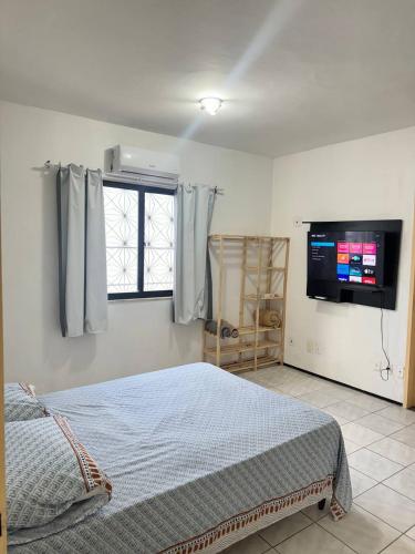 a bedroom with a bed and a flat screen tv at Ap no Derby com Garagem AC in Sobral