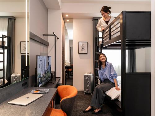 a woman sitting on top of a bunk bed at sequence SUIDOBASHI - Tokyo in Tokyo