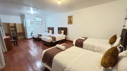um quarto de hotel com duas camas e uma sala de estar em Casona Liberty Inn em Cusco