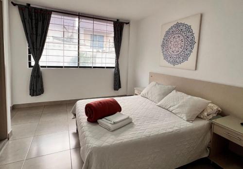 a bedroom with a white bed and a window at PARK 2009 Apartaestudios in Cali