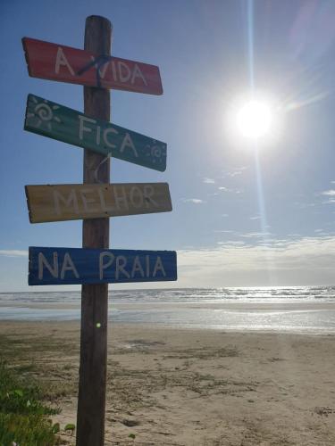 a street sign on the beach with signs on it at Pousada Lessa Beira Mar Centro Cidreira in Cidreira