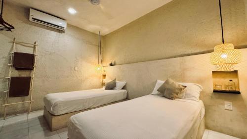 a hotel room with two beds and a mirror at Hotel Noah Tulum in Tulum