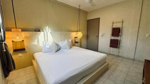 a bedroom with a large white bed in a room at Hotel Noah Tulum in Tulum