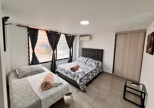 a bedroom with two beds with a baby sleeping on it at PARK 2009 Apartaestudios in Cali
