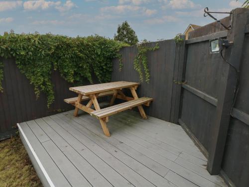 a wooden picnic table sitting on a wooden deck at 21 Heol Gylfinir in Barry