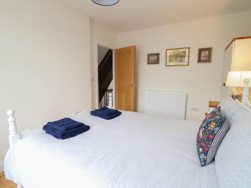 a bedroom with a white bed with blue towels on it at Osborne House in Rhayader