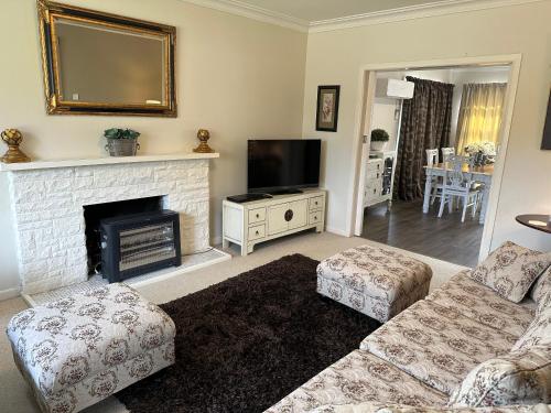 a living room with a fireplace and a tv at Cambridge Cottage - Self Catering Holiday House in Cambridge