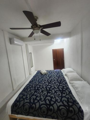 a bedroom with a bed with a ceiling fan at Casa Lao Bungalow in Zihuatanejo