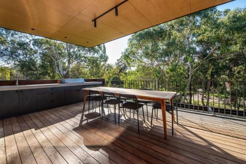 a wooden table on the deck of a house at Atlas Retreat in Shoreham