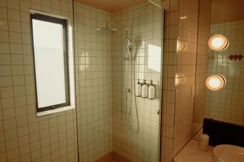 a bathroom with a shower with a window and a sink at Drifter Christchurch in Christchurch