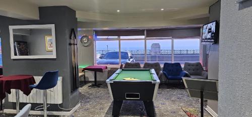 a room with a pool table and a room with a view at North Ocean Hotel in Blackpool