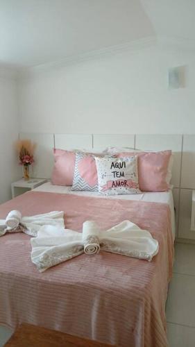 a bed with two white towels and a bow on it at Loft Outono Centro Histórico in Paraty