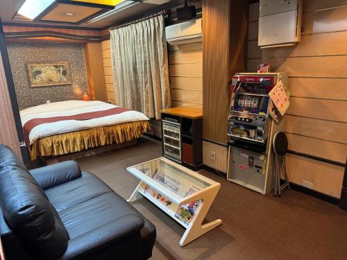 pokój z łóżkiem i kanapą w pokoju w obiekcie Himeji Baby Kiss (Adult Only) w mieście Himeji