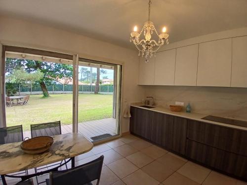 une cuisine avec une table et une salle à manger dans l'établissement Spacieuse maison familiale 11 pers. avec jardin près du port de Capbreton - FR-1-239-1001, à Capbreton