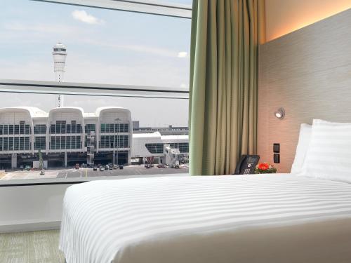a bedroom with a bed and a large window at Sama-Sama Express KLIA Terminal 2 - Airside Transit Hotel in Sepang