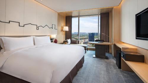 a hotel room with a large bed and a tv at Holiday Inn Nanjing Qinhuai South by IHG in Jiangning