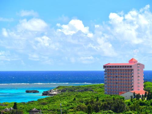 a building on a hill next to the ocean at Wellness Villa Brisa in Miyako Island