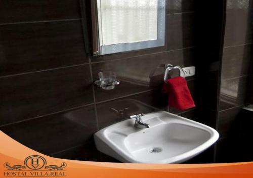 a bathroom with a sink and a red towel at HOSTAL VILLA.REAL in Quito