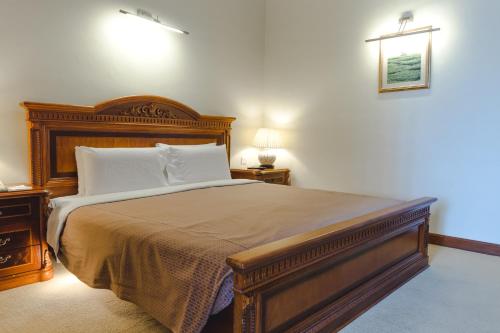 a bedroom with a large bed and two night stands at Heritage Hotel Cameron Highlands in Cameron Highlands