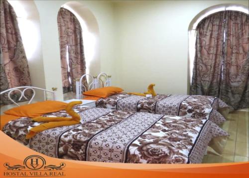 two beds sitting in a room with curtains at HOSTAL VILLA.REAL in Quito
