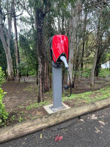 a red telephone sitting on the side of a road at Lincoln Downs Resort Batemans Bay in Batemans Bay