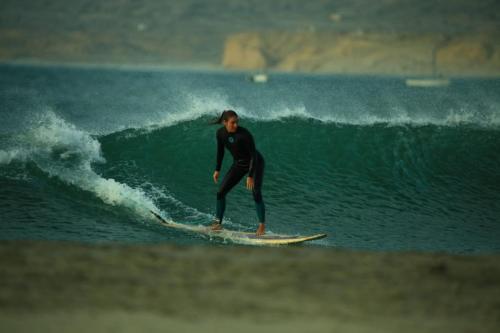 a man riding a wave on a surfboard in the ocean at Casa Lobos in Lobitos