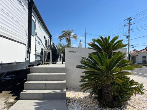 a group of palm trees sitting next to a train at オーシャンフロント館山 in Tateyama