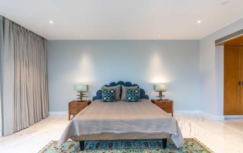 a bedroom with a large bed with blue walls at Amorzito by Solitaire Stays in Marmagao