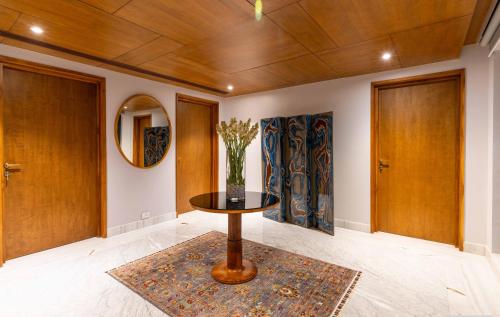 a room with a table with a vase on it at Amorzito by Solitaire Stays in Marmagao