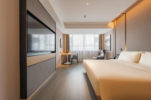 a hotel room with a bed and a tv at Atour Hotel Shanghai New International Expo Center South Yanggao Road in Shanghai