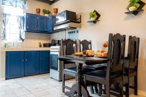a kitchen with blue cabinets and a table and chairs at J Flats in Malabar Settlement