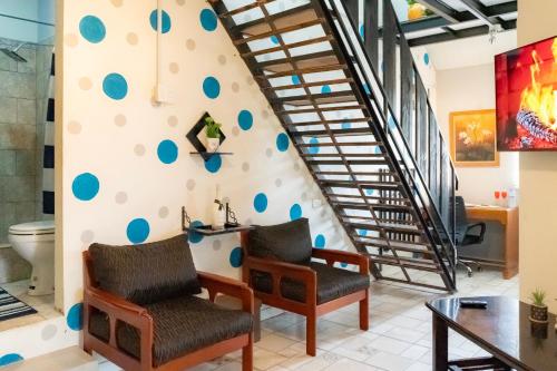 a room with two chairs and a staircase with blue dots on the wall at J Flats in Malabar Settlement