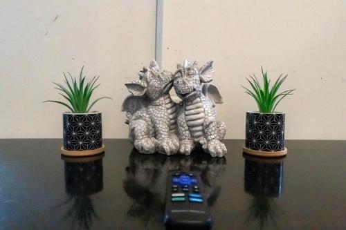 a remote control sitting on a table with two potted plants at J Flats in Malabar Settlement