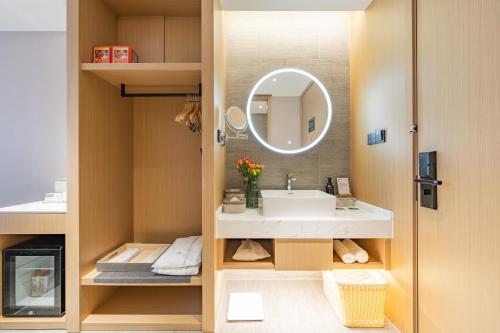 La salle de bains est pourvue d'un lavabo et d'un miroir. dans l'établissement Atour Hotel Shanghai New International Expo Center South Yanggao Road, à Shanghai