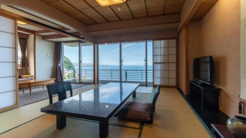 a dining room with a table and a view of the ocean at Kissho Caren in Higashiizu