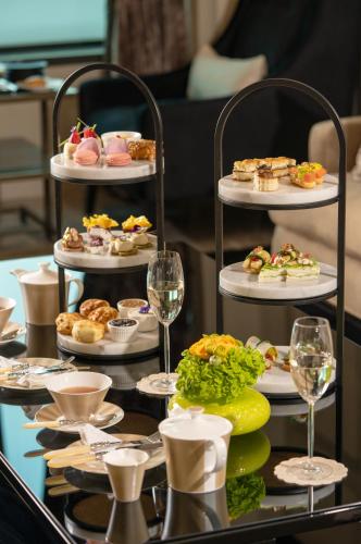 a table with three tiers of food and glasses of wine at Fairmont Riyadh in Riyadh
