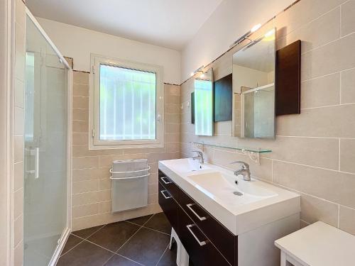 une salle de bain avec un lavabo, un miroir et une fenêtre dans l'établissement Spacieux appartement 3 chambres avec jardin, centre-ville Antibes, 6 couchages, proche plages et commerces - FR-1-789-1, à Antibes