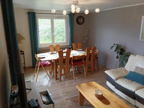un salon avec une table, des chaises et un canapé dans l'établissement Maison 8 pers avec jardin et garage à Autrans - FR-1-737-82, à Autrans