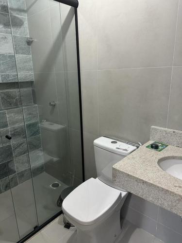 a bathroom with a toilet and a shower and a sink at Condomínio Mares do Sul in Salinópolis