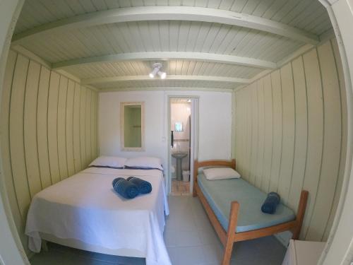 a small room with two beds and a mirror at Pousada Bela Vista in Ilha do Mel
