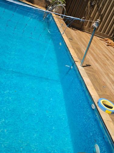 a blue swimming pool with a net in it at Hostel Sol e Luar in Franca