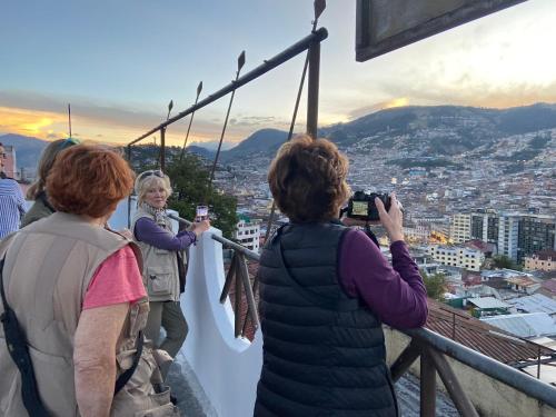 um grupo de mulheres tirando fotos de uma cidade em Hostal La Terraza em Quito