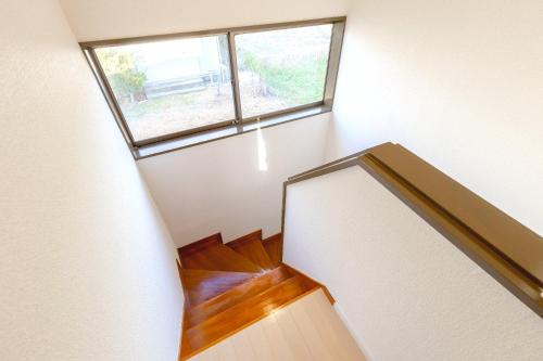 a spiral staircase with a window in a house at ANGO Kujukuri II in Katakai