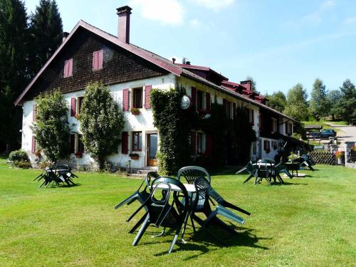 eine Gruppe von Tischen und Stühlen vor einem Gebäude in der Unterkunft Auberge du Grammont in Ramonchamp