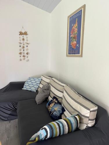 ein Sofa mit Kissen darauf im Zimmer in der Unterkunft Casa Corsa à Moorea in Moorea