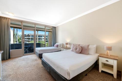 a hotel room with two beds and a balcony at Comfort Resort Waters Edge in Port Macquarie
