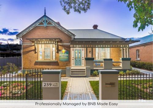 a brick house with a fence in front of it at Blue Door Apartment - CBD Location, 2 Bed 2 Bath in Orange
