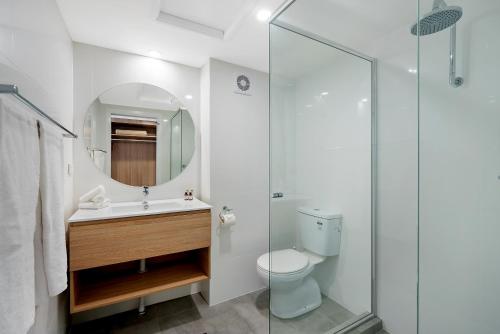 a bathroom with a sink and a toilet and a mirror at Comfort Resort Waters Edge in Port Macquarie